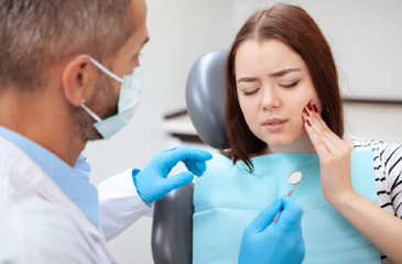 woman in pain holding her face in hand I emergency dentistry burien WA