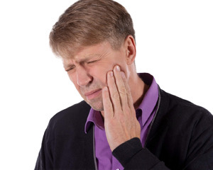 man in pain holding his jaw I TMJ treatment burien WA