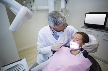 Dentist performing dental exam l General Dentist Burien WA